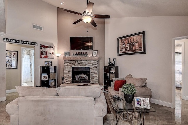 living room with a stone fireplace, high vaulted ceiling, and ceiling fan