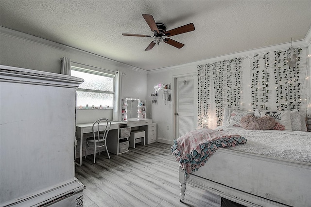 bedroom featuring ceiling fan, ornamental molding, a textured ceiling, and light wood-type flooring