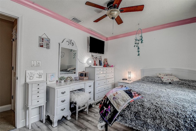 bedroom with crown molding, a textured ceiling, ceiling fan, and light hardwood / wood-style floors