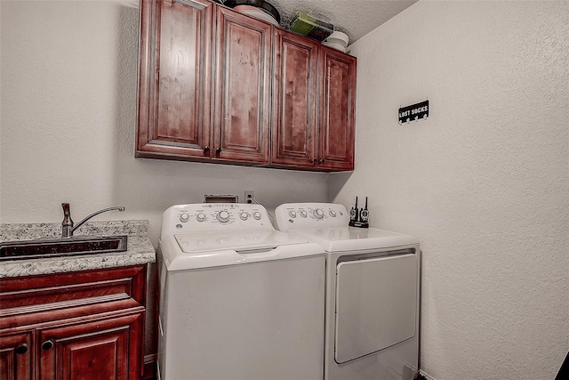 clothes washing area featuring cabinets, washer and dryer, and sink