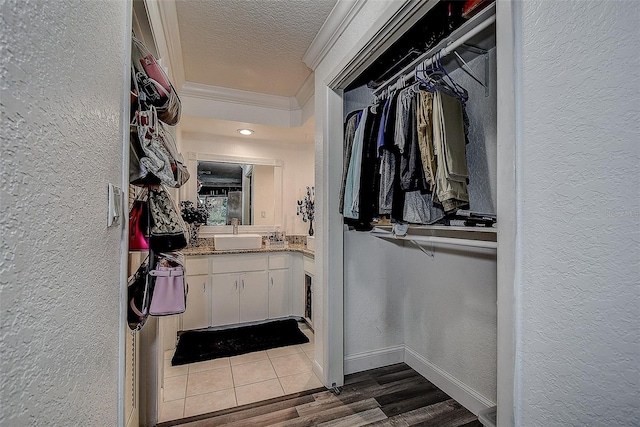 walk in closet featuring hardwood / wood-style flooring and sink