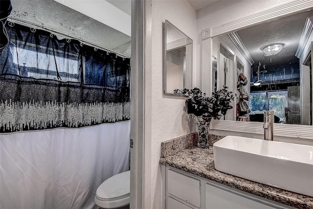 bathroom with sink, curtained shower, toilet, and a textured ceiling