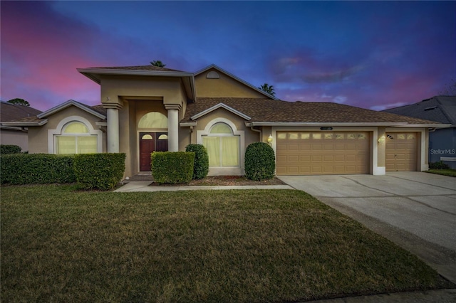 view of front of house with a yard and a garage