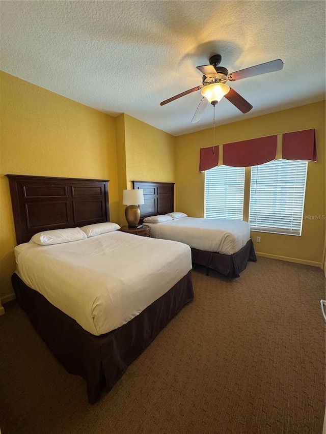 carpeted bedroom with ceiling fan and a textured ceiling