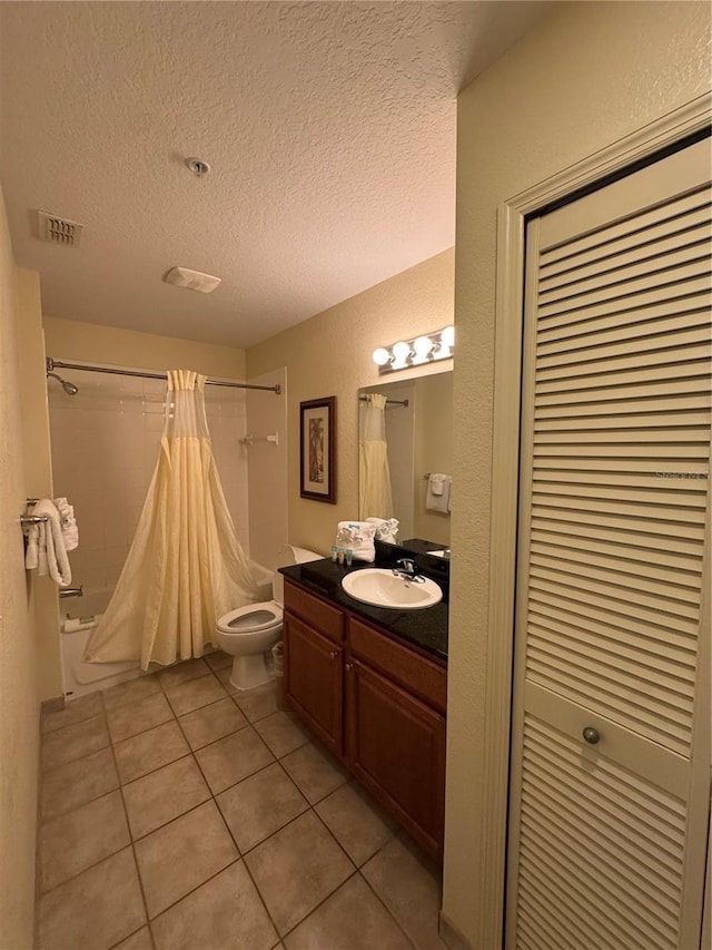 full bathroom with tile patterned flooring, vanity, a textured ceiling, toilet, and shower / bath combo with shower curtain