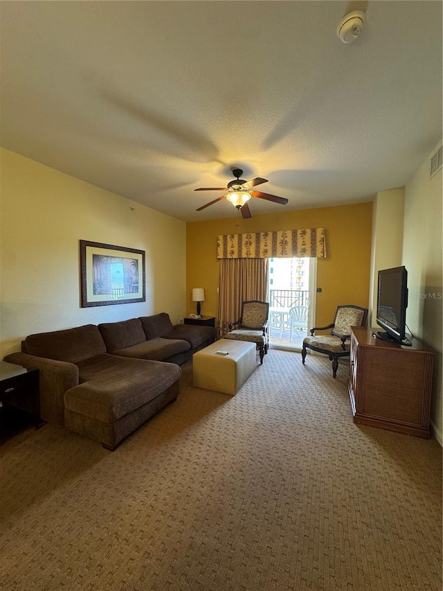 carpeted living room with ceiling fan and a textured ceiling