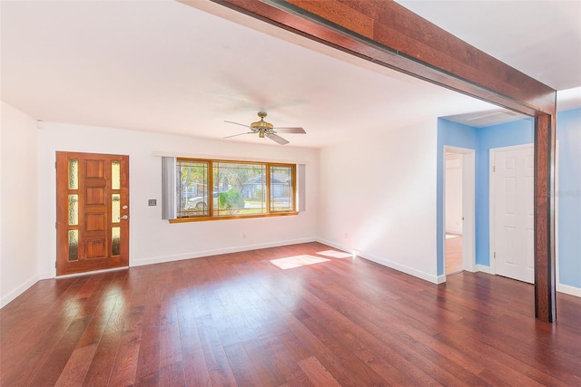 unfurnished living room featuring dark wood-style floors, beam ceiling, ceiling fan, and baseboards