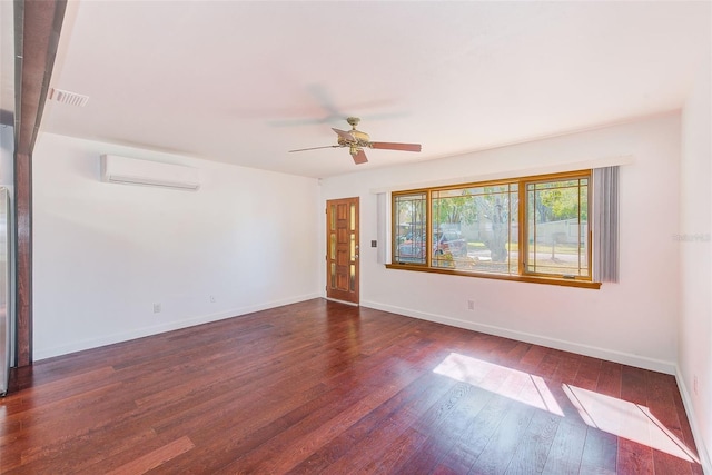 empty room featuring dark wood-style floors, visible vents, an AC wall unit, and baseboards