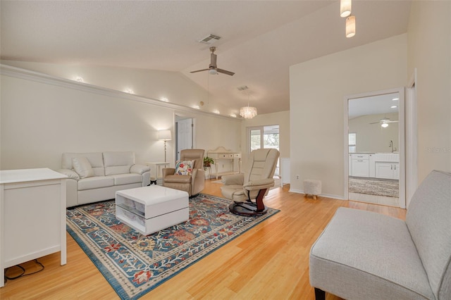 living room with ceiling fan, wood-type flooring, sink, and vaulted ceiling