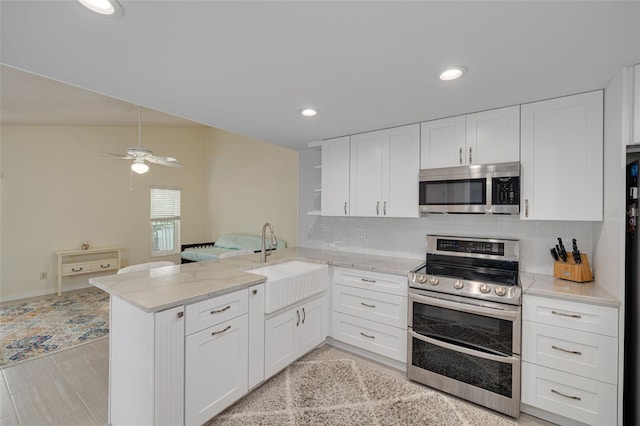 kitchen featuring sink, stainless steel appliances, kitchen peninsula, and white cabinets