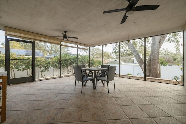 unfurnished sunroom with ceiling fan