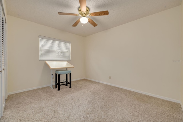 carpeted empty room featuring ceiling fan and a textured ceiling