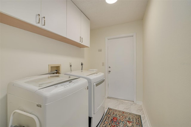 laundry area featuring independent washer and dryer and cabinets