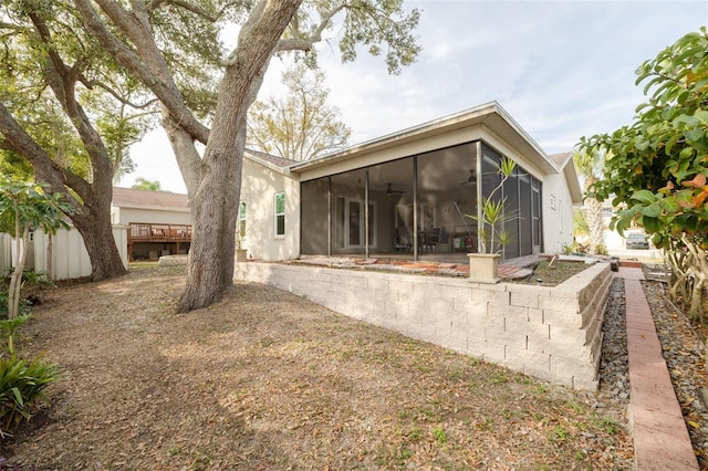 rear view of property with a sunroom and ceiling fan