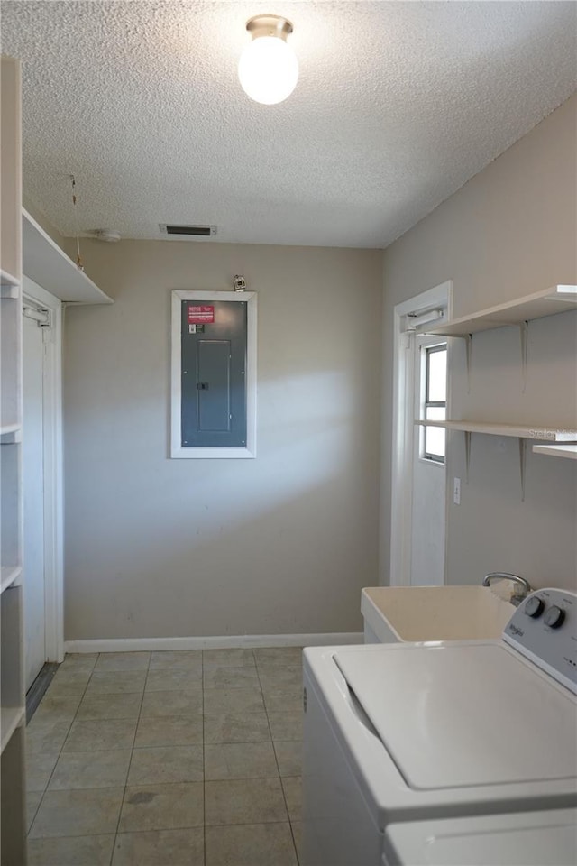 clothes washing area featuring tile patterned floors, washer / clothes dryer, electric panel, and a textured ceiling