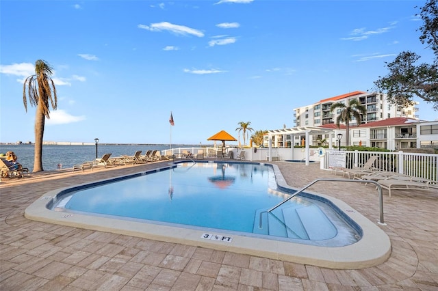 view of pool with a water view and a patio area