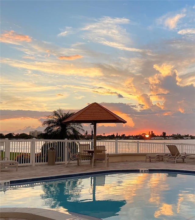 pool at dusk with a patio