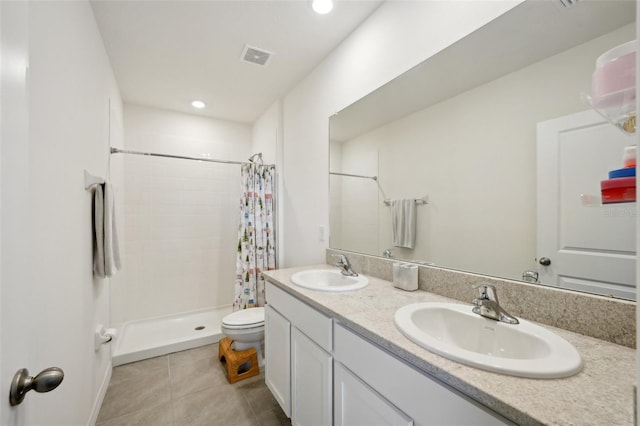 bathroom featuring vanity, tile patterned floors, toilet, and walk in shower