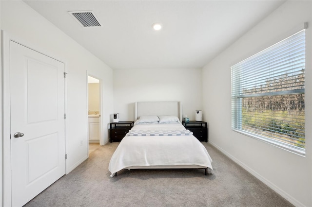 carpeted bedroom featuring ensuite bath