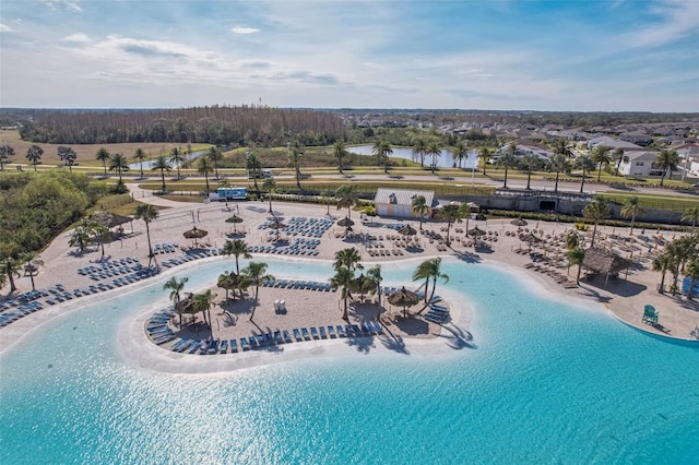 birds eye view of property featuring a water view and a beach view