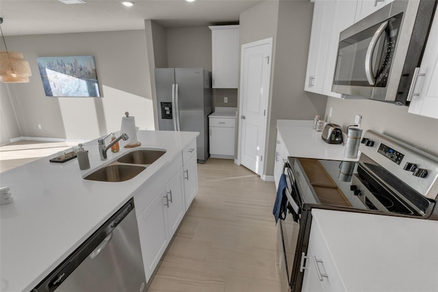 kitchen with pendant lighting, sink, white cabinets, and appliances with stainless steel finishes