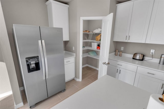 kitchen featuring stainless steel fridge with ice dispenser and white cabinets