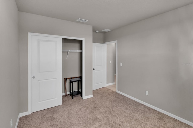 unfurnished bedroom with light carpet and a closet