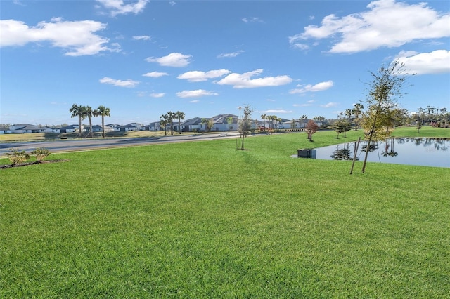 view of property's community featuring a water view and a lawn