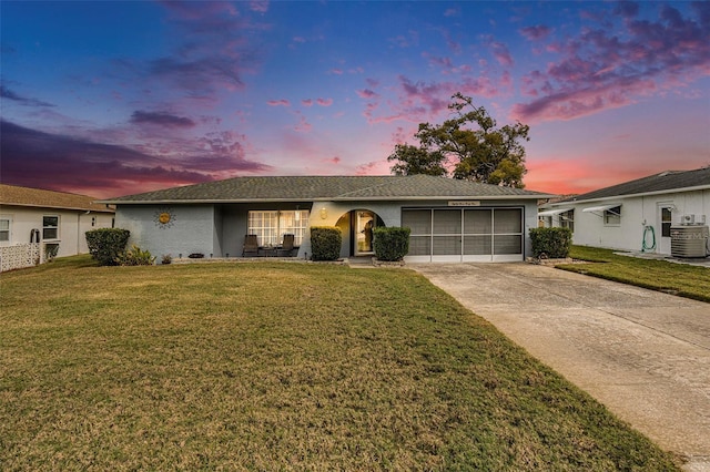 ranch-style house featuring cooling unit, a garage, and a yard