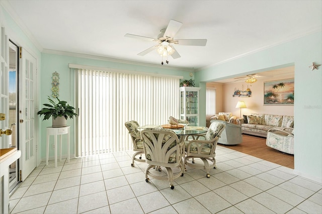 tiled dining space with ceiling fan and ornamental molding