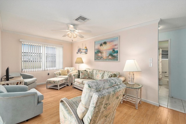 living room with ornamental molding, a textured ceiling, ceiling fan, and light hardwood / wood-style flooring