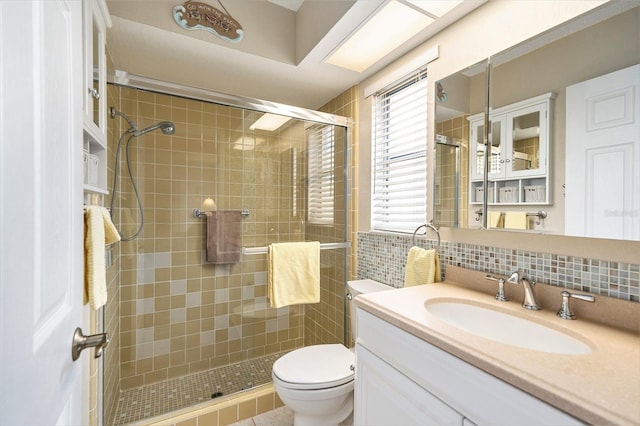 bathroom with vanity, an enclosed shower, backsplash, and toilet