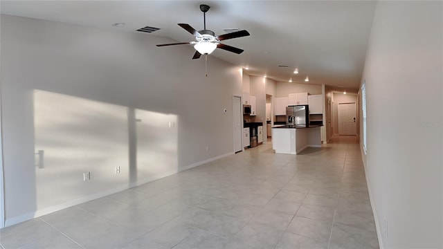 unfurnished living room with vaulted ceiling, ceiling fan, and light tile patterned flooring