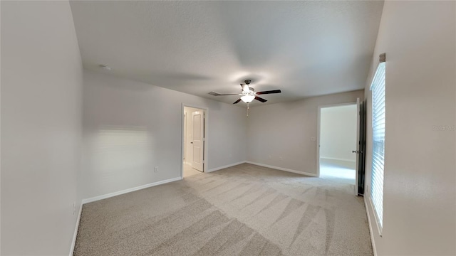 empty room featuring light colored carpet and ceiling fan