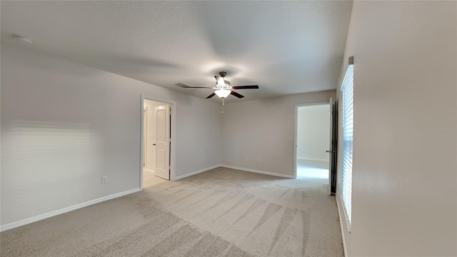 carpeted spare room featuring a textured ceiling and ceiling fan