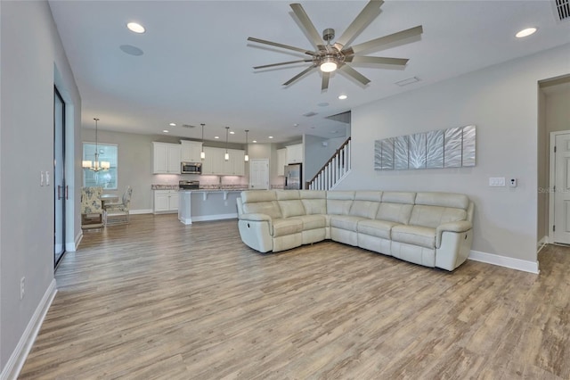 living room with an inviting chandelier and light hardwood / wood-style floors