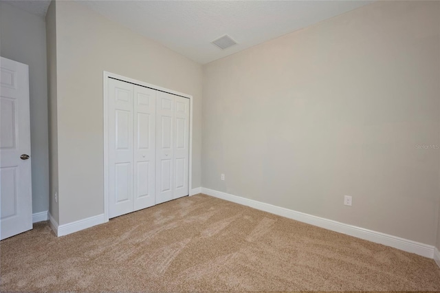 unfurnished bedroom with carpet flooring and a closet