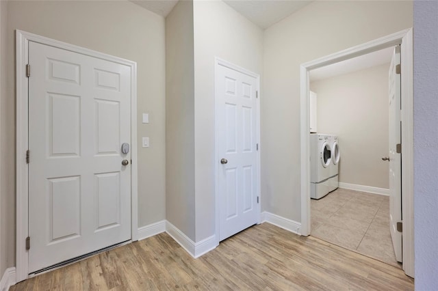 entryway with separate washer and dryer and light hardwood / wood-style flooring