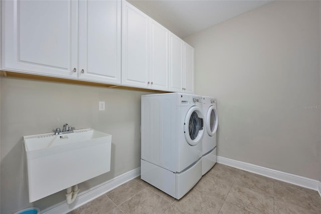 washroom with sink, washer and clothes dryer, cabinets, and light tile patterned flooring