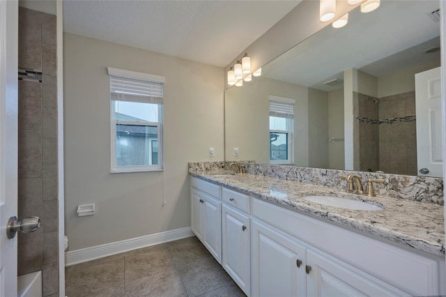 bathroom featuring tile patterned flooring, vanity, a tile shower, and toilet