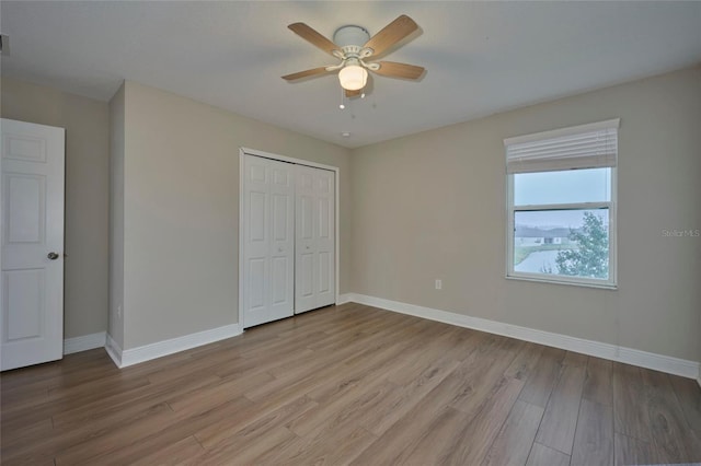 unfurnished bedroom with a closet, ceiling fan, and light hardwood / wood-style flooring