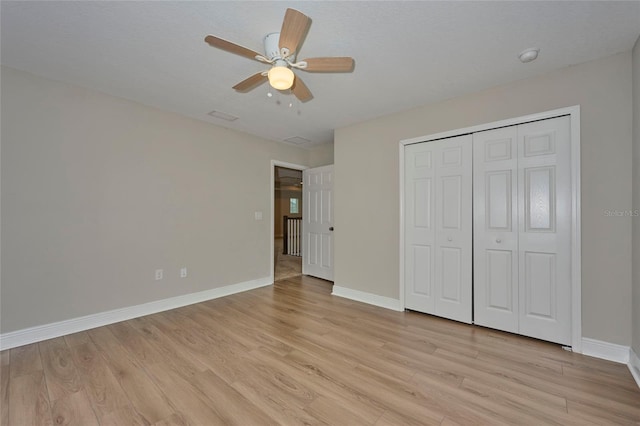 unfurnished bedroom featuring ceiling fan, light hardwood / wood-style floors, and a closet