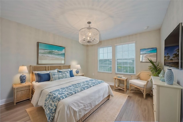 bedroom featuring light hardwood / wood-style floors and a notable chandelier