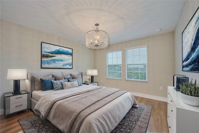 bedroom featuring hardwood / wood-style flooring and an inviting chandelier