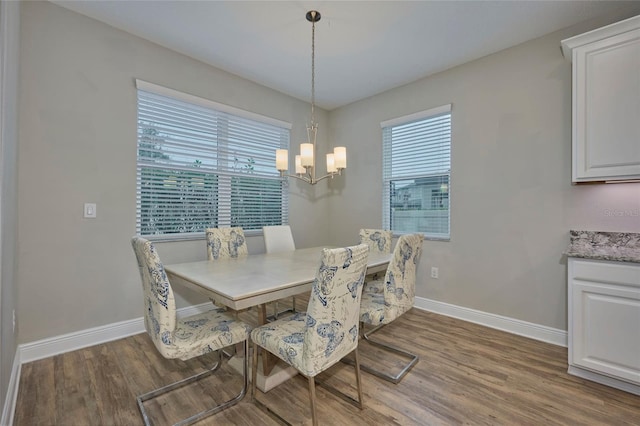 dining space with dark wood-type flooring and a chandelier