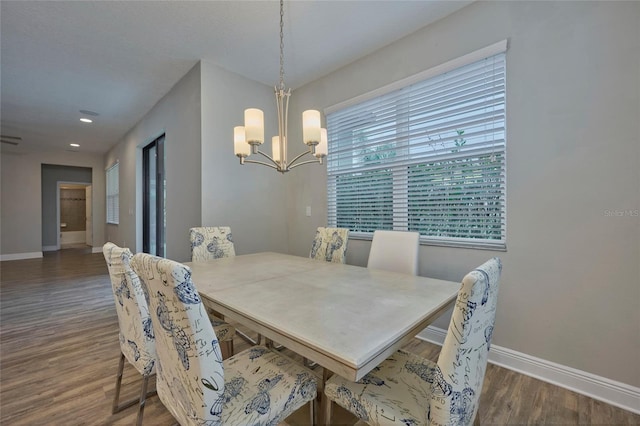 dining area featuring dark wood-type flooring and a notable chandelier