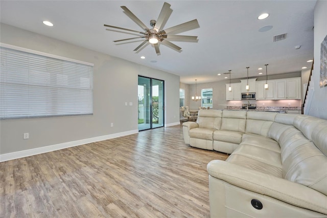 living room with light wood-type flooring and ceiling fan