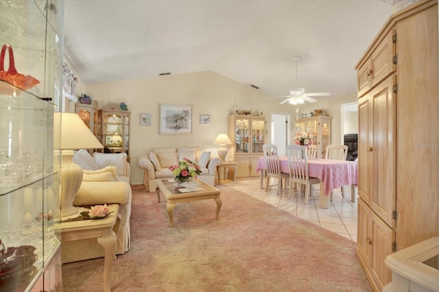 living room featuring lofted ceiling, light tile patterned floors, and ceiling fan