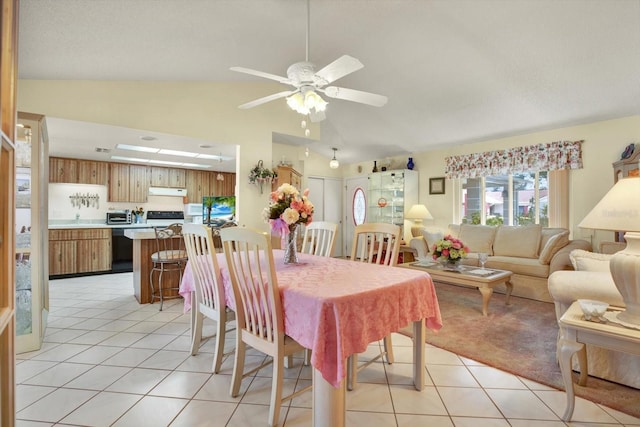 dining room featuring light tile patterned flooring, vaulted ceiling, and ceiling fan