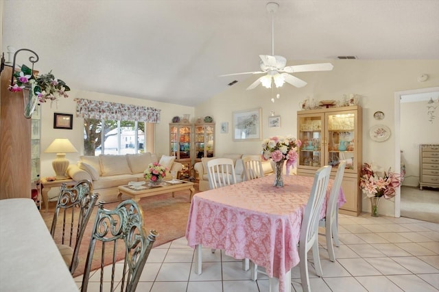 tiled dining room with ceiling fan and lofted ceiling